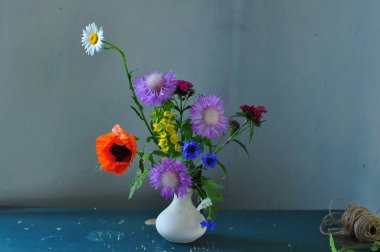 Tahta bir arka planda vazoda güzel bir buket çiçek.