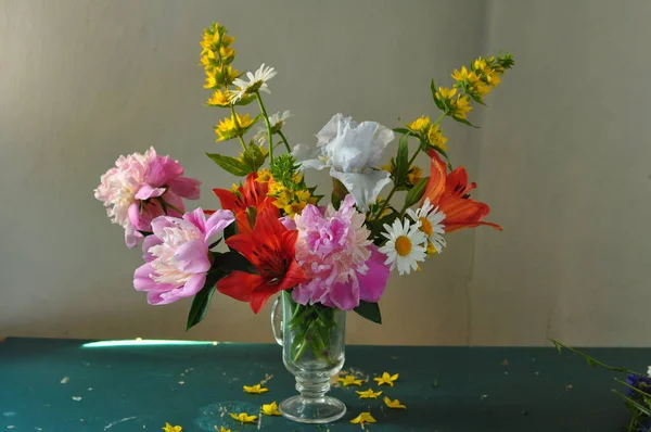 stock image beautiful bouquet of flowers in a glass vase on a wooden background