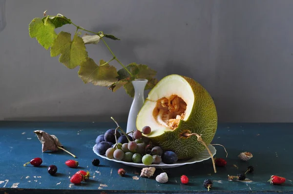 stock image ripe melon, grapes and a bouquet of summer flowers