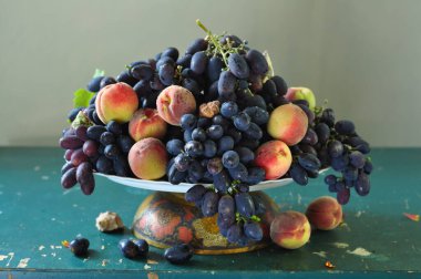 Masada olgun mavi üzümler ve diğer meyvelerle dolu bir hayat.