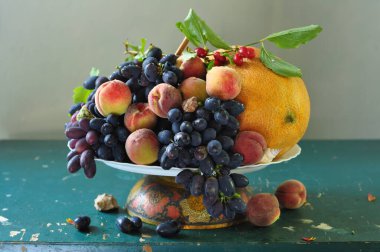 Masada olgun mavi üzümler ve diğer meyvelerle dolu bir hayat.