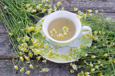 Beyaz ahşap arka planda çiçekli taze papatya çayı. 