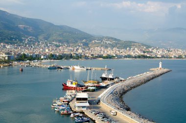 Portakallı klasik bir saatin dikey yakın çekimi. Masada bir karpuz ve bir saat var. 