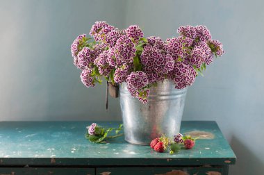 Gri arka planda, ahşap masada, güzel bir demet vahşi lavanta. 