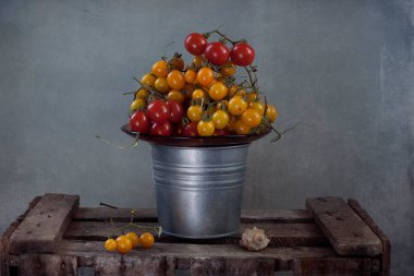 Tahta bir masada sepetteki kiraz domatesleri 