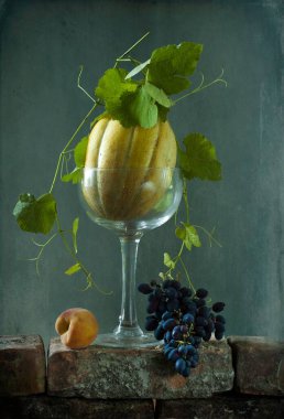 Bir bardak taze üzüm ve mavi arka planda bir şişe şampanyayla sakin bir hayat. durgun hayat 