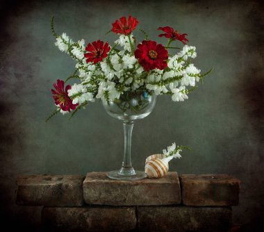 Hayat kırmızı güller ve karanlık arka planda bir vazo çiçekle dolu 