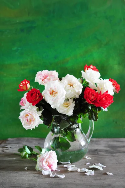 beautiful bouquet of red roses in a vase on wooden background