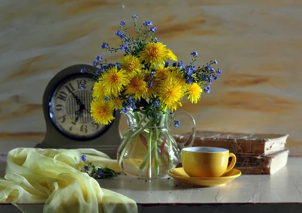 木製のテーブルの上に黄色の花と黄色の花の花束 まだ黄色の花と黄色の花の花束と青の花瓶と生活 — ストック写真