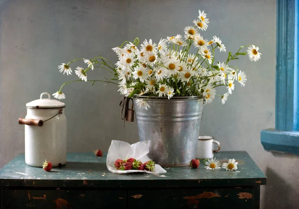 bouquet of daisies in the vase on wooden table