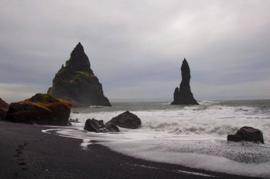 Siyah kaya oluşumları İzlanda 'daki Vvik' teki siyah kum üzerinde. 