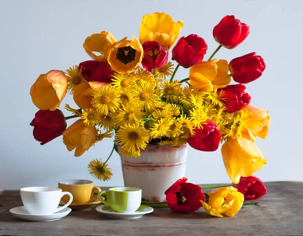 Masadaki vazoda sarı ve kırmızı laleler 