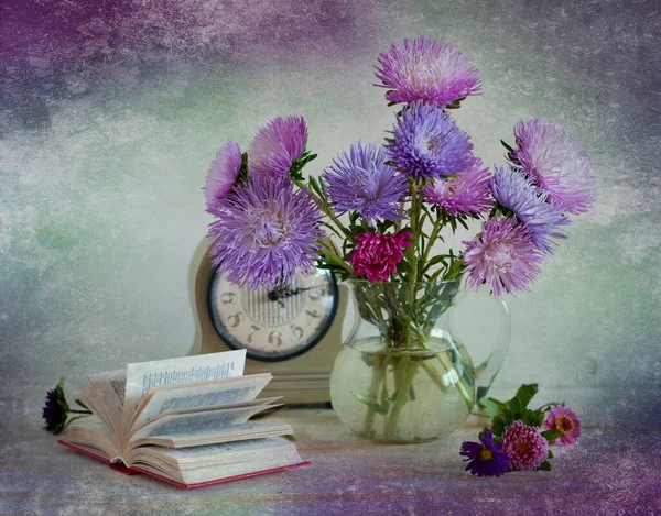 beautiful purple flowers on old books and vintage wooden background.