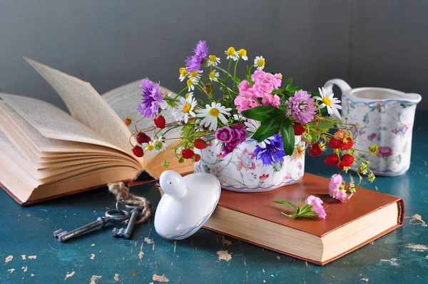 still life with a bouquet of flowers and a book