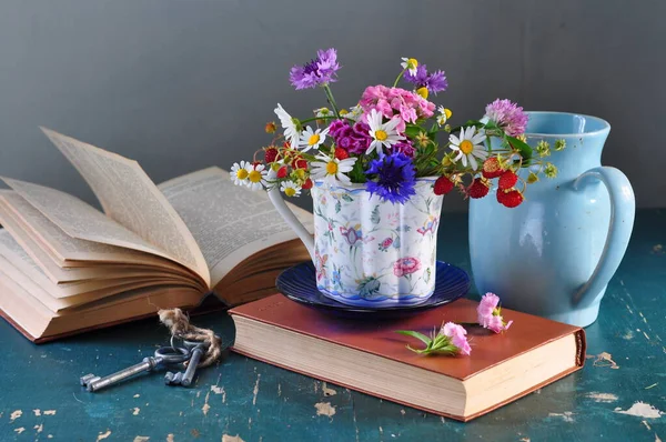 still life with flowers, books, glass of tea, books, flowers and a bouquet of wild flowers