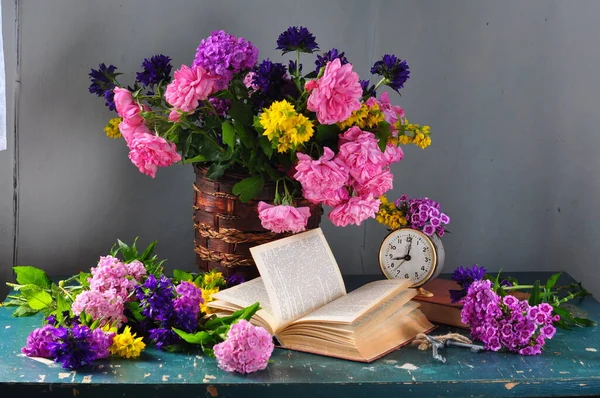 bouquet of flowers, books, a vase and a bouquet of flowers on a blue wooden table
