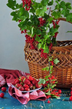 Olgun böğürtlenli sepet ve bir sepet yabani çilek ahşap masa üzerinde, sonbahar konsepti. 