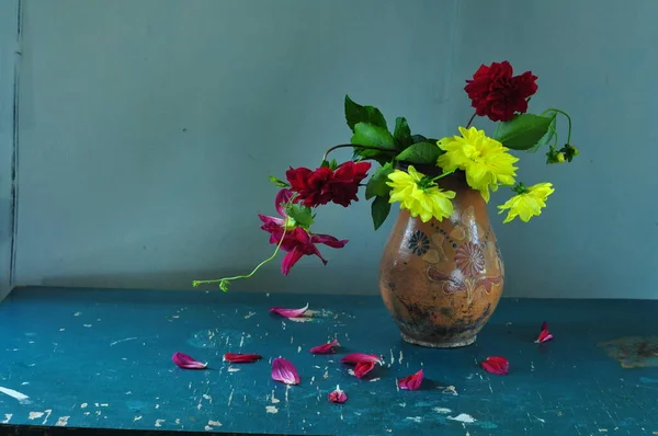 Blumenstrauß Und Eine Kanne Mit Wasser Auf Blauem Hintergrund — Stockfoto