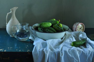 Yeşil bir salatalık, limon ve tahta bir masada bir fincan çay..