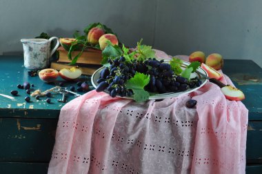 Taze erikler ve ahşap bir masada bir demet üzüm..