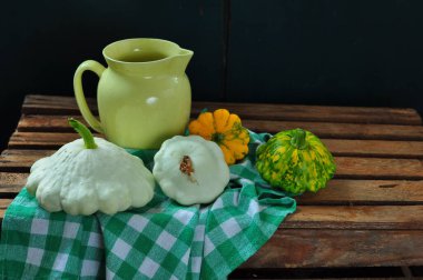 Arka planda balkabağı ve yeşil yapraklarla dolu bir hayat. Balkabağı ve sonbahar yapraklarıyla hayat.