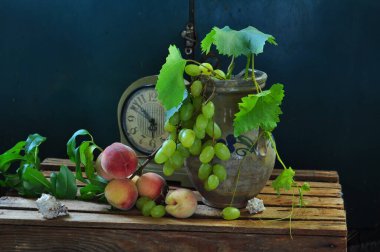 Tahta bir masadaki cam vazoda olgun yeşil üzümler. Taze böğürtlenlerle hayat.