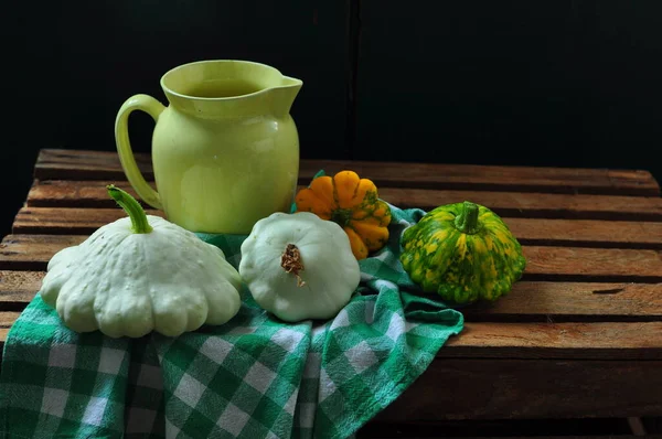 green pumpkins with herbs and spices on wooden table