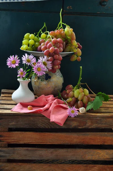 Vazoda üzümler ve çiçekler.