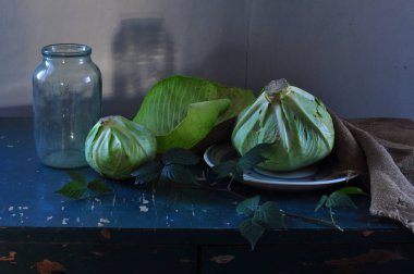 Karanlık arka planda lahana ve salatalıkla dolu bir hayat