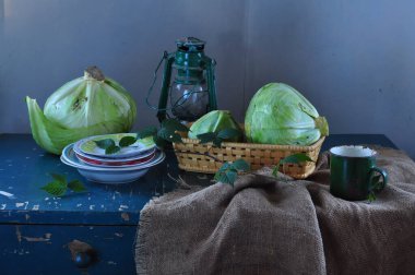 Bir cam kasede yeşil soğan ve tahta bir tahtanın üzerinde bıçakla.