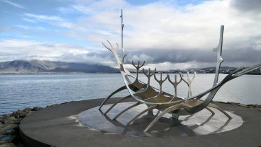 Bulutlu bir gökyüzünün arka planında, denizin ahşap heykelinin yakın plan çekimi.