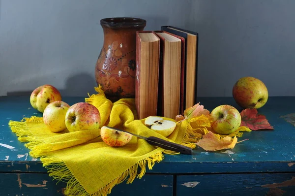 still life of a book with apples and a book