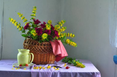 Bir vazoda sarı laleler, bir buket sarı çiçekler ve bir pipetle.