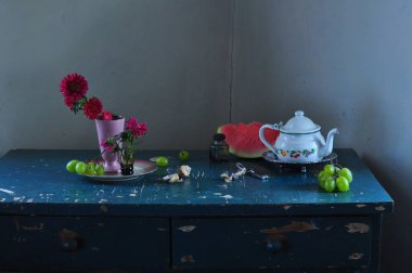 Çiçekler ve çaydanlıkla dolu bir masa