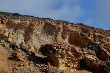 Mavi gökyüzünün altında kayalık bir sahilin güzel manzarası