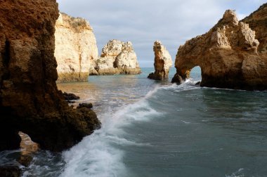 Bulutlu bir günde deniz olan kayalık bir sahil manzarası