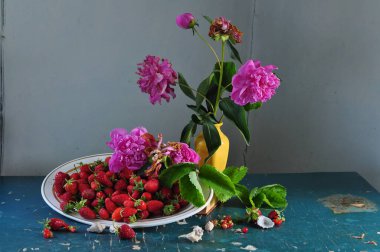 Bir buket kırmızı çiçek ve bir fincan ile durgun bir hayat