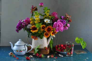 Bir buket çiçek ve çaydanlıkla hayat dolu.