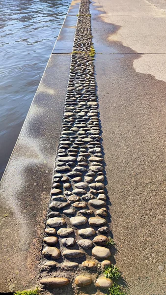 Kıyıdaki suyun kıyısında çakıl taşı yolu.