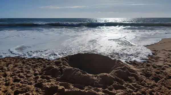 Sular yükselmeden önce kumsalda büyük bir delik var.