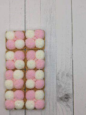 Pembe arka planda dört pembe beyaz kurabiye, yanal konum