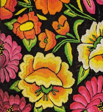 Sarı, pembe, turuncu ve yeşil işlemeli Meksika geleneksel nakışı. Çiçekler ve yapraklar