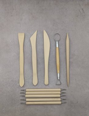 Çimento arka planında birleştirilmiş ahşap ve metal heykel araçları