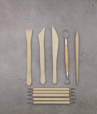 Gri çimento arka planında birleşik ahşap ve metal heykel araçları