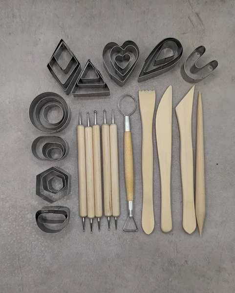 Metal cutters, wooden and metal sculpt tools on gray cement background