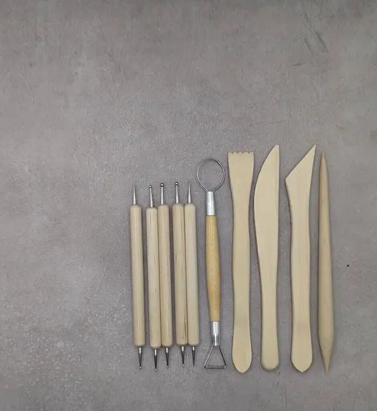 Wooden and metal sculpt tools on cement background