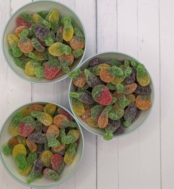 Beyaz ahşap arka planda meyveli sakızlı üç alıcı.