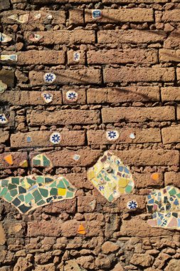 Mexican decorative wall made of mud bricks and parts of colorful tiles at tepoztlan clipart
