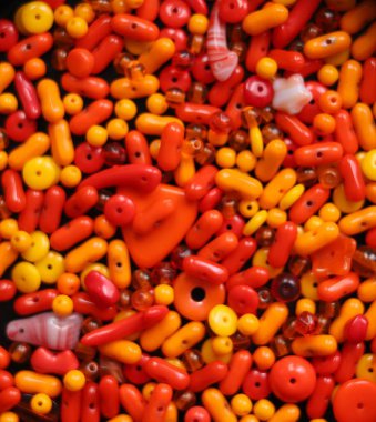 Turuncu ve farklı şekillerde sarı cam boncuklar.