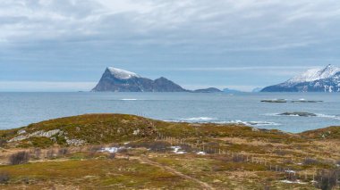 Okyanusun ötesine, adanın dik yamaçlarına, Hya 'nın Trom açıklarına, okyanustan Kuzey Atlantik' e yükselişine. Norveç 'in kuzeyinde, Trom' da, renkli sabah ışığında karlı dağlar. 